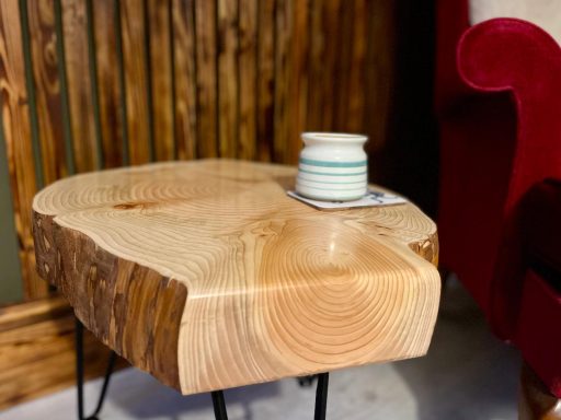 Natural wooden side table with a ceramic cup and coaster on top.